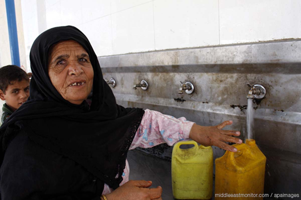 palestinian-lady-filling-a-water-bottle-in-gaza