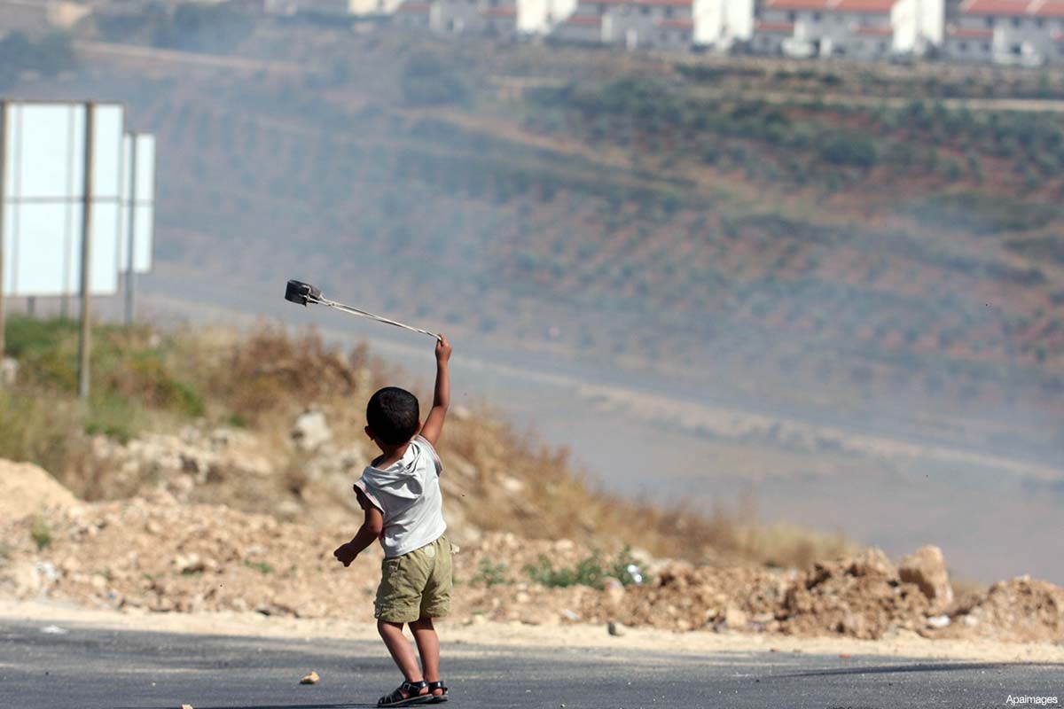 palestinian-child-rock-throwing-israeli-settlement-in-the-distance